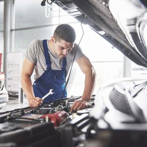 muscular car service worker repairing vehicle